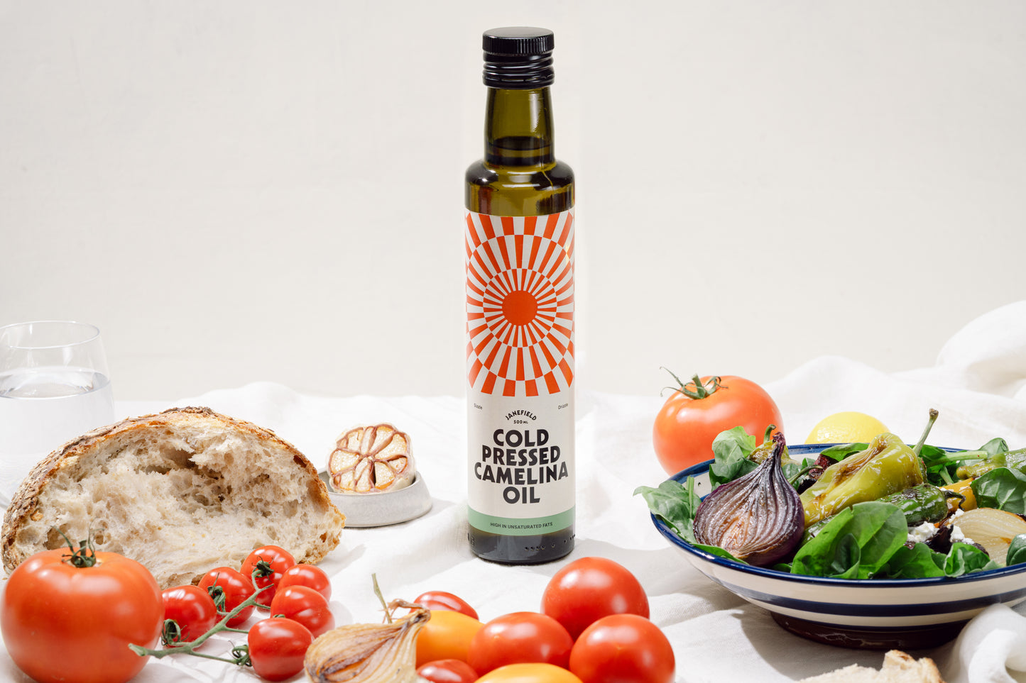 Cold pressed camelina oil bottle with fresh food.